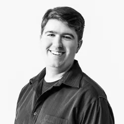 Jamieson Roberts in a dark collared shirt appearing in front of a white background wall.